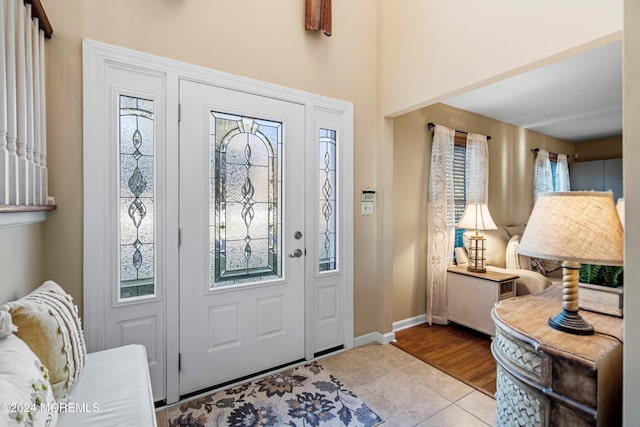 foyer featuring light tile patterned flooring and a healthy amount of sunlight