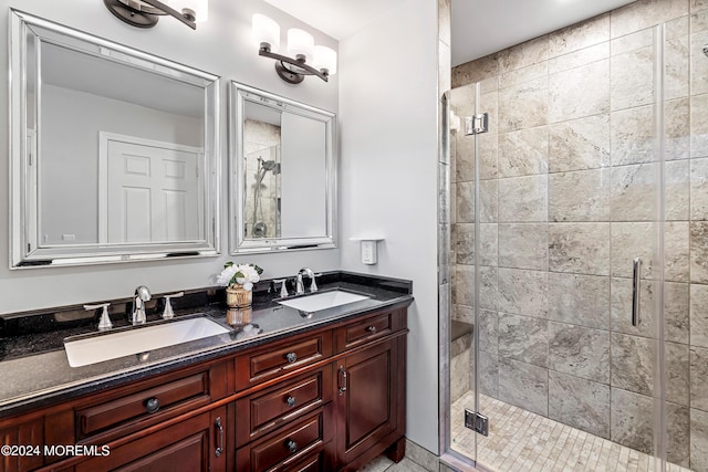 bathroom featuring a shower with shower door and vanity