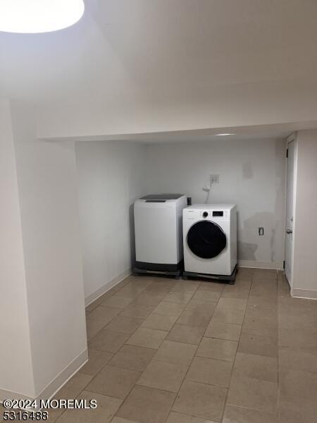 clothes washing area featuring independent washer and dryer and light tile patterned floors