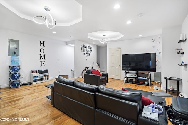 living room with hardwood / wood-style floors, electric panel, and a tray ceiling