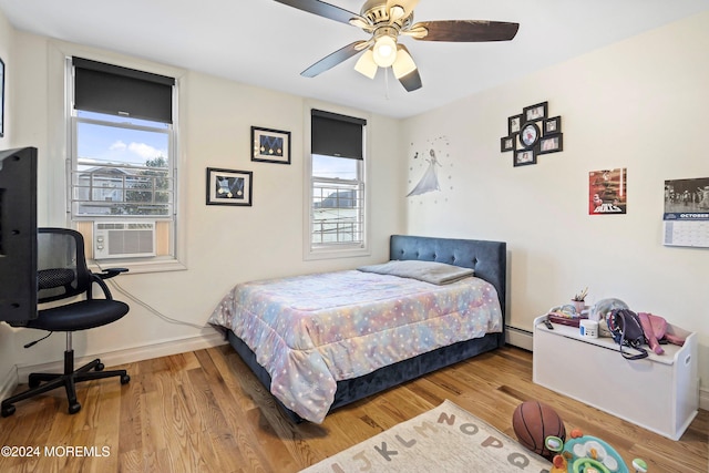 bedroom featuring cooling unit, hardwood / wood-style floors, a baseboard radiator, and ceiling fan