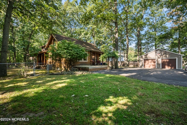 view of yard featuring an outbuilding, a garage, and central AC unit