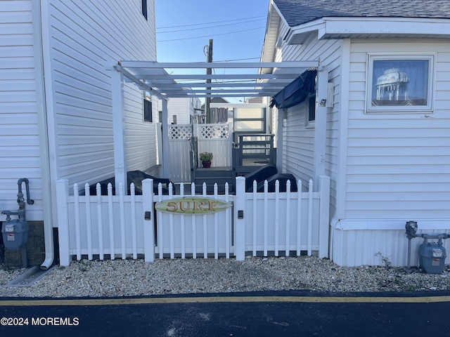 exterior space featuring fence and roof with shingles