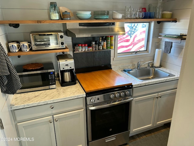 kitchen featuring light stone counters, sink, and appliances with stainless steel finishes