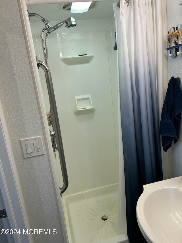 bathroom with sink and a shower with shower curtain