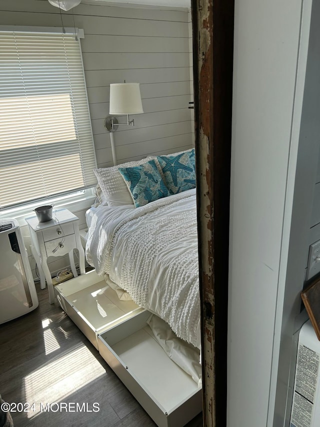 bedroom featuring wood walls and dark hardwood / wood-style flooring