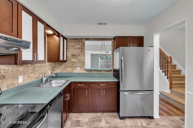 kitchen featuring tasteful backsplash, appliances with stainless steel finishes, sink, and light hardwood / wood-style flooring