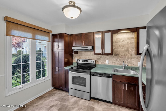 kitchen featuring dark brown cabinetry, stainless steel appliances, sink, and backsplash