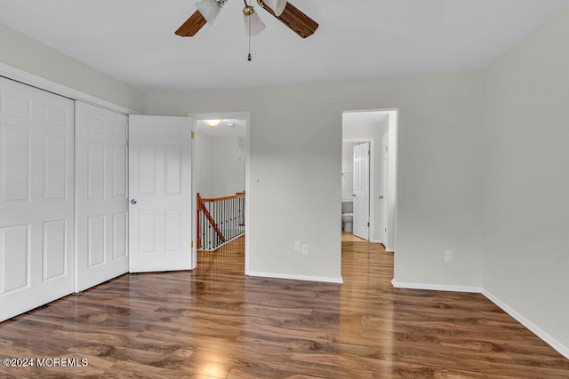 unfurnished bedroom with dark wood-type flooring, ceiling fan, and a closet