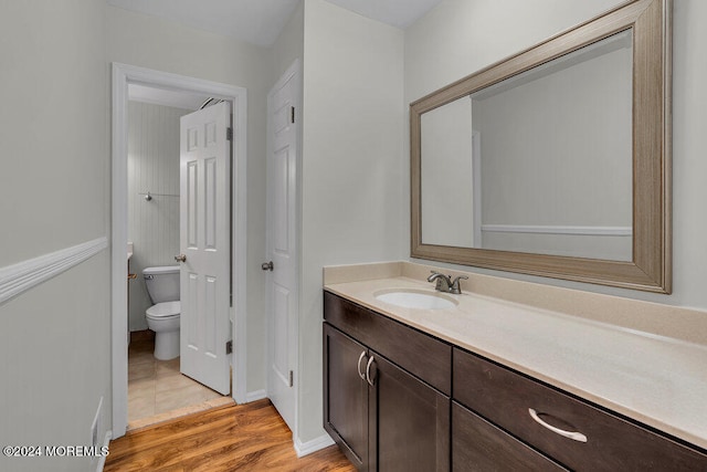 bathroom featuring toilet, vanity, and hardwood / wood-style floors