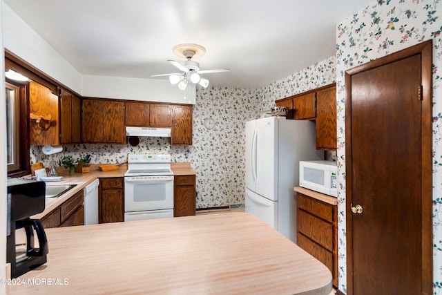 kitchen with white appliances, ceiling fan, and kitchen peninsula