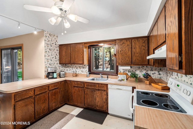 kitchen featuring kitchen peninsula, tasteful backsplash, ceiling fan, sink, and white appliances