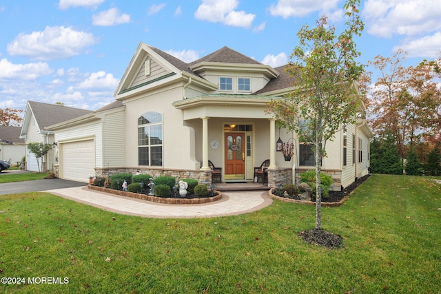 view of front of home with covered porch, a front yard, and a garage