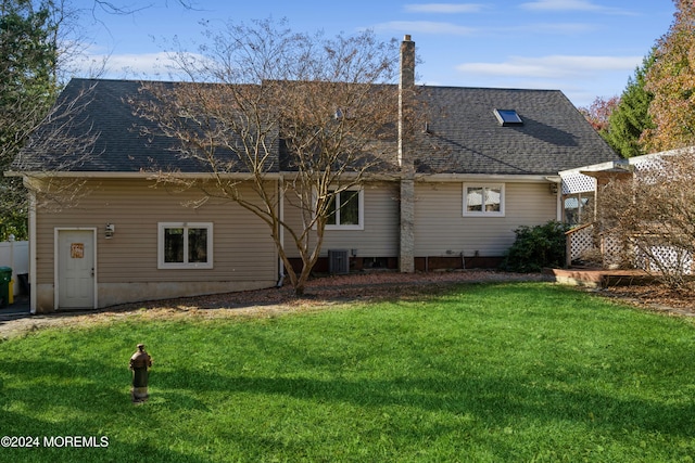 back of house with cooling unit and a yard