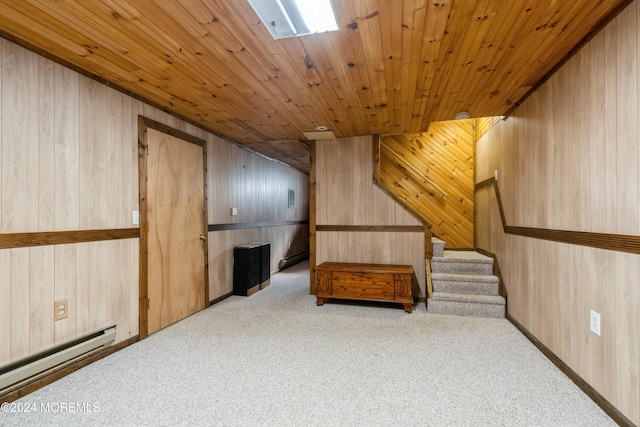 additional living space featuring a baseboard radiator, light colored carpet, and wood walls