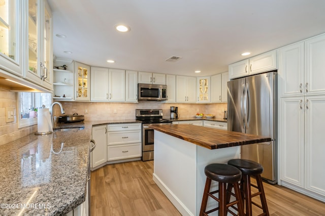 kitchen with sink, white cabinets, stainless steel appliances, and light wood-type flooring