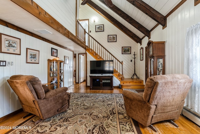 living room featuring wooden walls, a baseboard heating unit, beam ceiling, high vaulted ceiling, and hardwood / wood-style floors