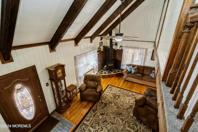 living room with hardwood / wood-style floors, a wood stove, and wood walls