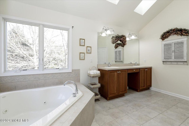 bathroom with lofted ceiling with skylight, vanity, tile patterned flooring, and tiled tub