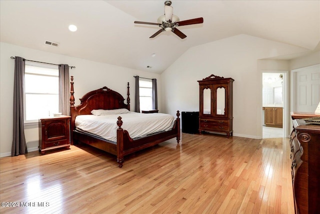 bedroom with ensuite bath, lofted ceiling, ceiling fan, and light hardwood / wood-style flooring