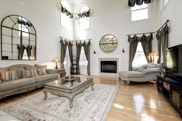 living room with a high ceiling and light wood-type flooring