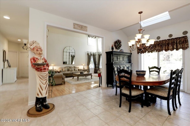 dining area featuring light hardwood / wood-style flooring, a notable chandelier, and a skylight