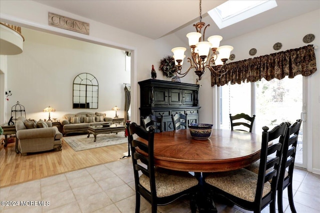 dining area featuring a chandelier, light hardwood / wood-style flooring, and a skylight