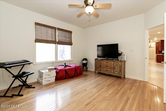 game room with ceiling fan and light wood-type flooring