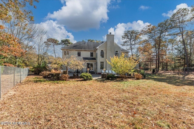 back of property featuring a patio area and a yard