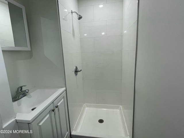 bathroom with vanity and a tile shower