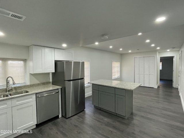 kitchen with appliances with stainless steel finishes, white cabinetry, sink, and dark hardwood / wood-style flooring