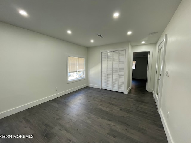 unfurnished bedroom with a closet and dark hardwood / wood-style flooring