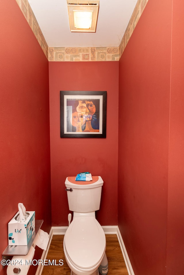 bathroom with toilet and hardwood / wood-style flooring