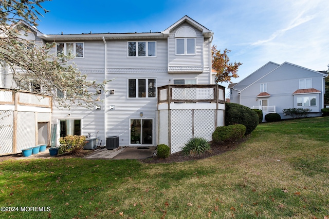 rear view of property featuring a patio, central AC, and a lawn