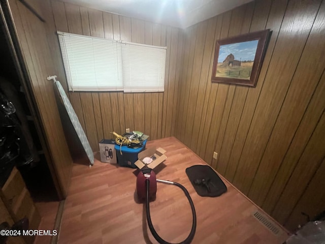 misc room featuring wood-type flooring and wood walls