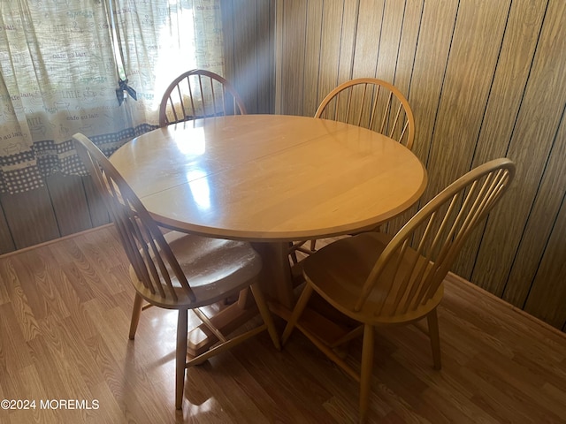 dining area featuring hardwood / wood-style floors and wooden walls