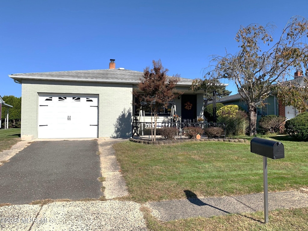 ranch-style house featuring a front lawn and a garage