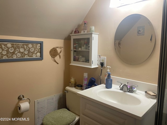 bathroom with vanity, toilet, and lofted ceiling