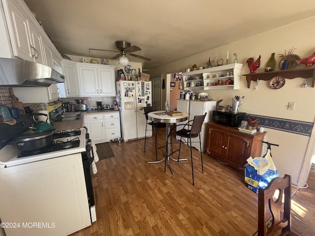 kitchen featuring dark hardwood / wood-style flooring, white appliances, ceiling fan, white cabinets, and range hood