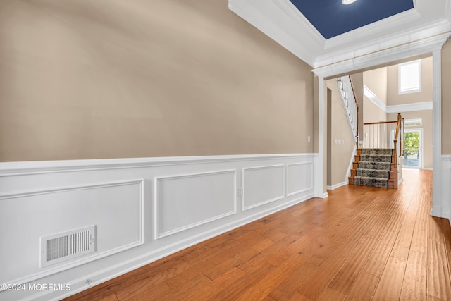 empty room with hardwood / wood-style flooring and ornamental molding