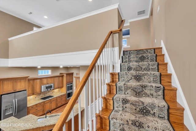 stairway featuring crown molding, hardwood / wood-style floors, and sink