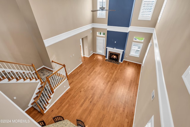 living room with hardwood / wood-style floors, a high ceiling, and ceiling fan