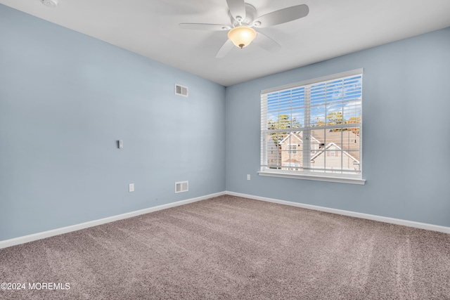 carpeted spare room featuring ceiling fan