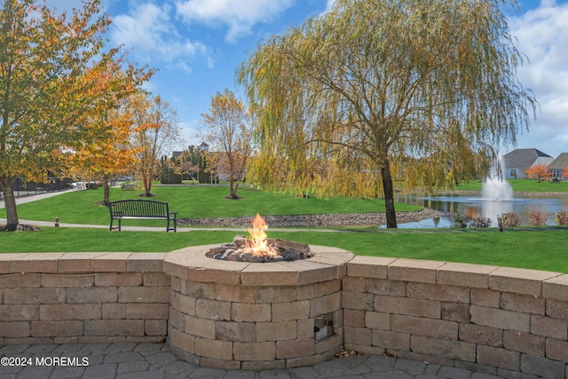 view of patio featuring a water view and a fire pit