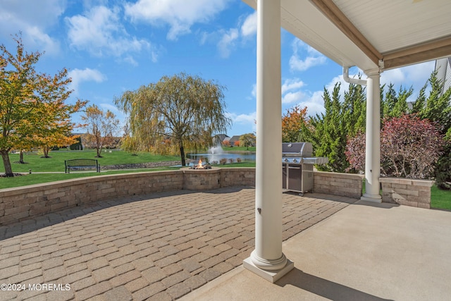 view of patio featuring an outdoor kitchen, grilling area, and a water view