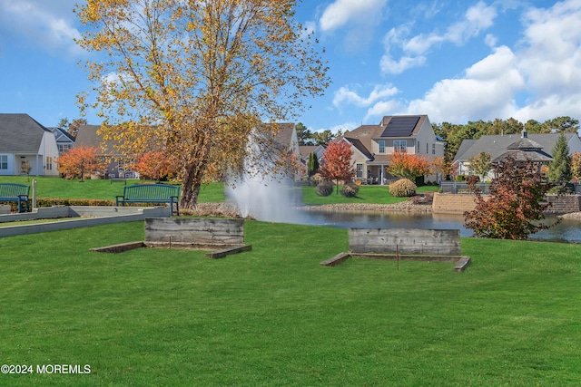 view of home's community featuring a yard and a water view