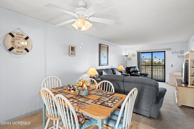 carpeted dining room featuring ceiling fan