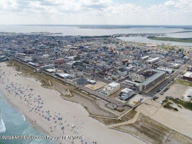 drone / aerial view featuring a water view and a beach view