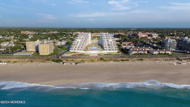 drone / aerial view featuring a water view and a beach view