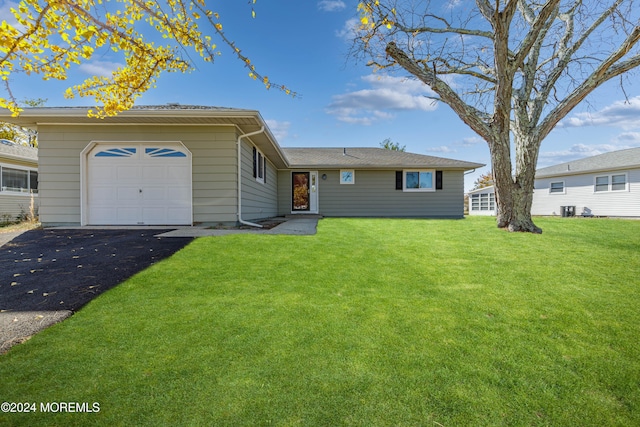 single story home featuring a front lawn and a garage